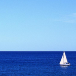 Парусная яхта плывет по безкрайнему синему морю
