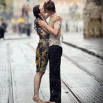 Парень и девушка целуются под дождём
